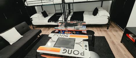 A bunk bed room with a gaming table in the center.