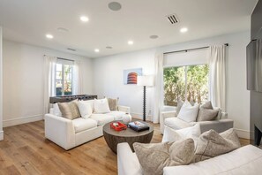 Ein modernes Wohnzimmer mit einer Sofagarnitur, einem Couchtisch und einem Flachbildfernseher.