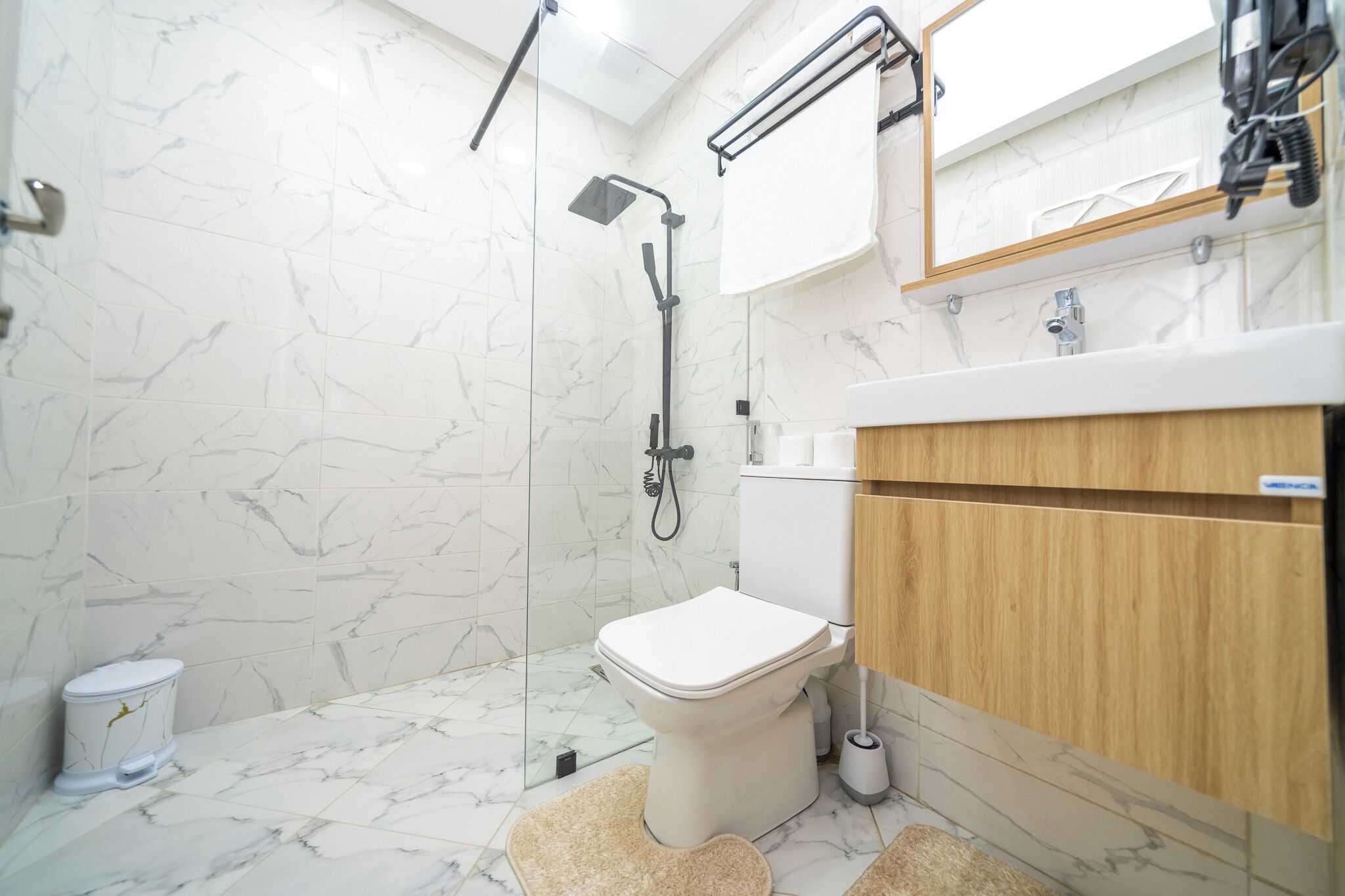 A modern bathroom with a shower, toilet, and vanity.