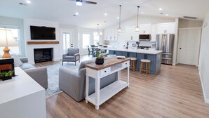 A modern kitchen with white cabinets, stainless steel appliances, and a central island. - The Coler House - Near Coler Bike Trails (Bentonville)