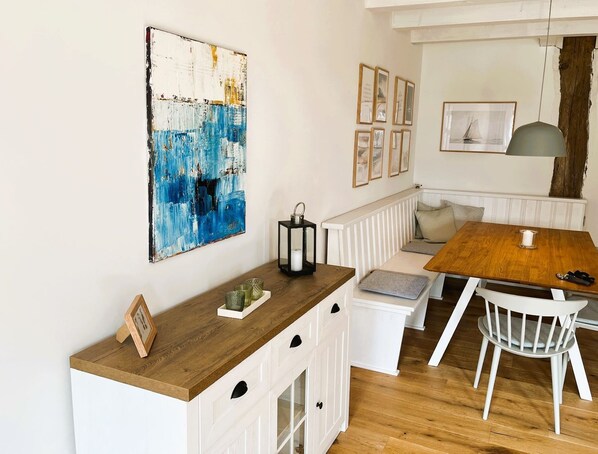 A cozy kitchen with a wooden countertop, white cabinetry, and a bench seating area.