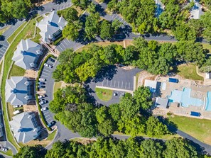Vista aérea de una zona residencial con varias casas, una piscina y un estacionamiento.