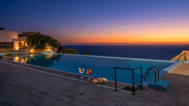 A swimming pool with a sunset view, a bar area, and a stone pathway. - Le Dalie With Shared Pool, Marinella, Italy (Marinella)