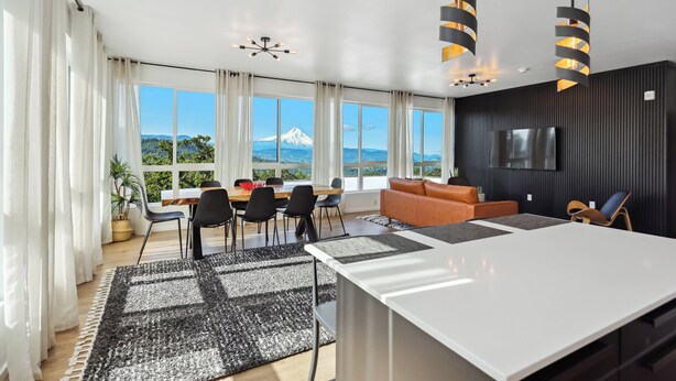 A modern living room with a large window, a dining area, and a kitchen. - One-bedroom honeymoon penthouse, Mt Hood views, downtown White Salmon, suite 16 (White Salmon)