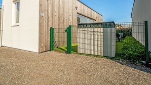 A modern building with a wooden facade and a metal gate.