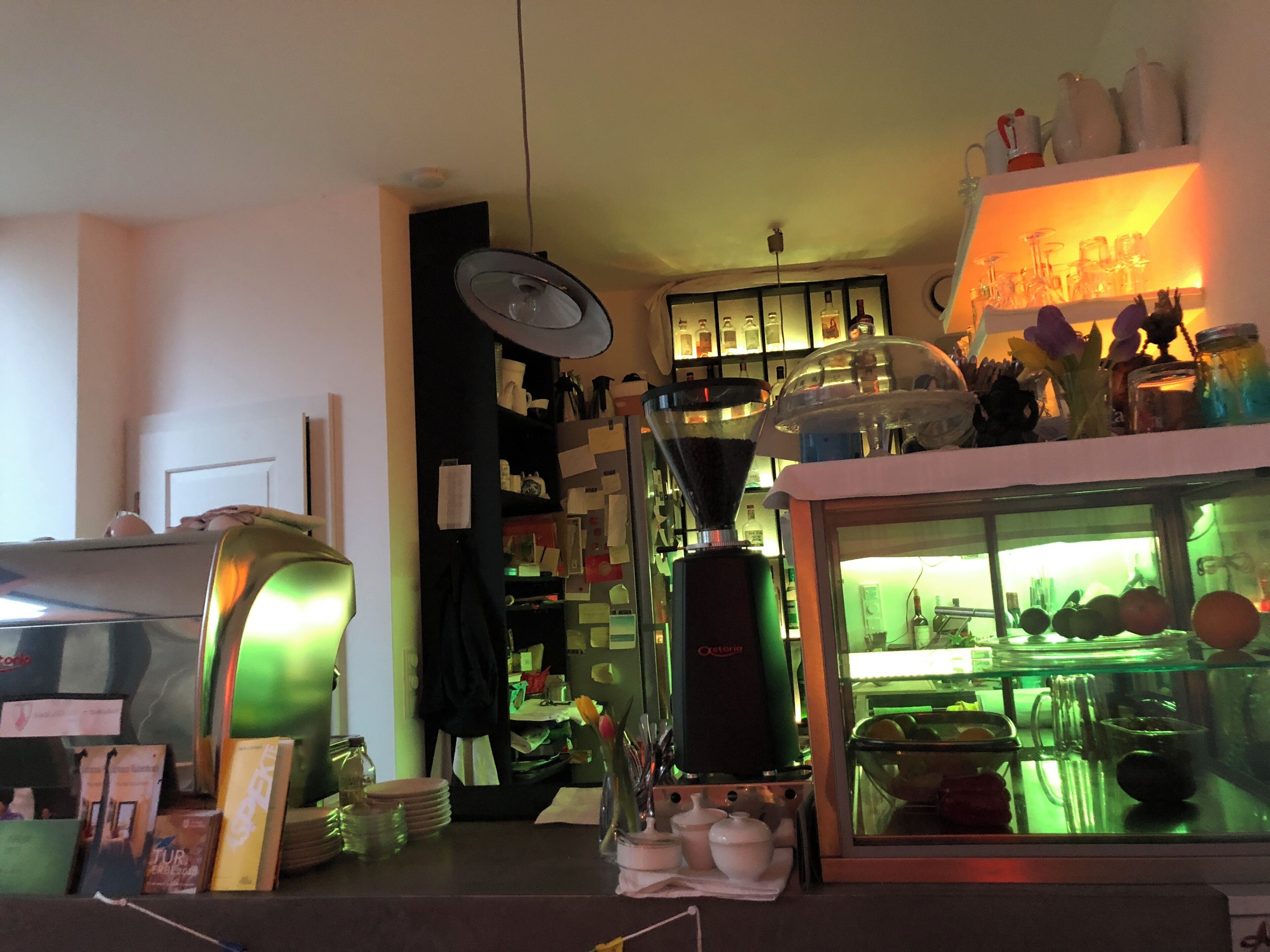 Una cocina con cafetera, refrigerador y diversos utensilios de cocina.