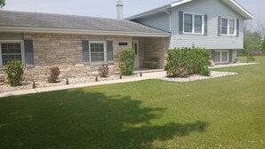 A two-story house with a stone facade and a blue exterior.