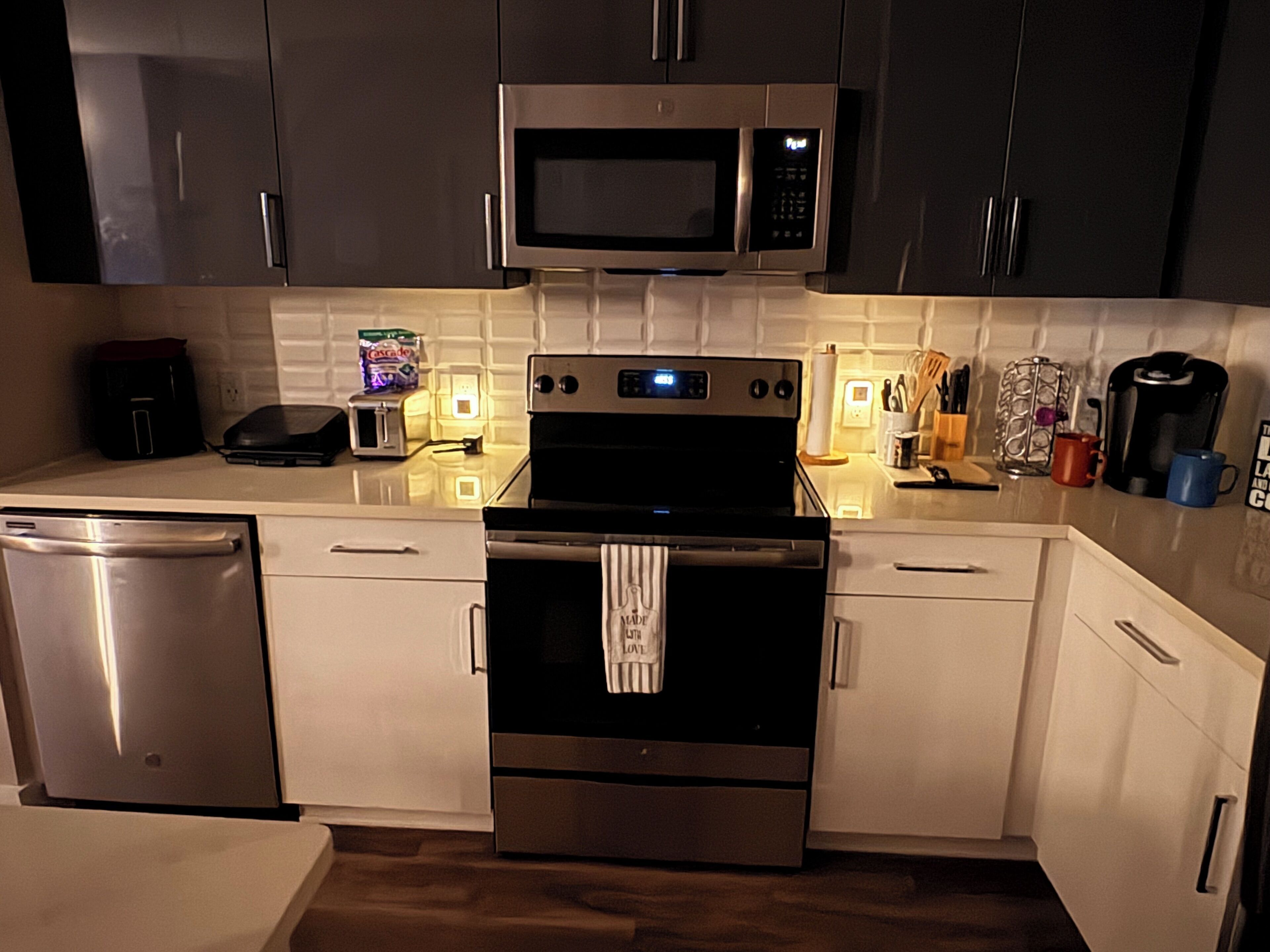 A modern kitchen with stainless steel appliances, a microwave, a toaster, and a coffee maker.