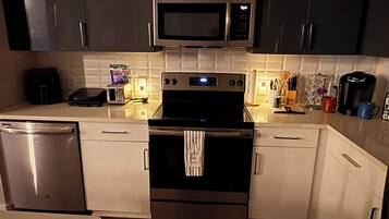 A modern kitchen with stainless steel appliances, a microwave, a toaster, and a coffee maker.