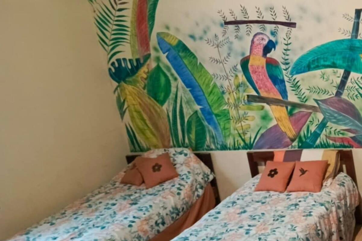 Ett rum med två separata sängar, båda med blommig sängklädsel och matchande kuddar.