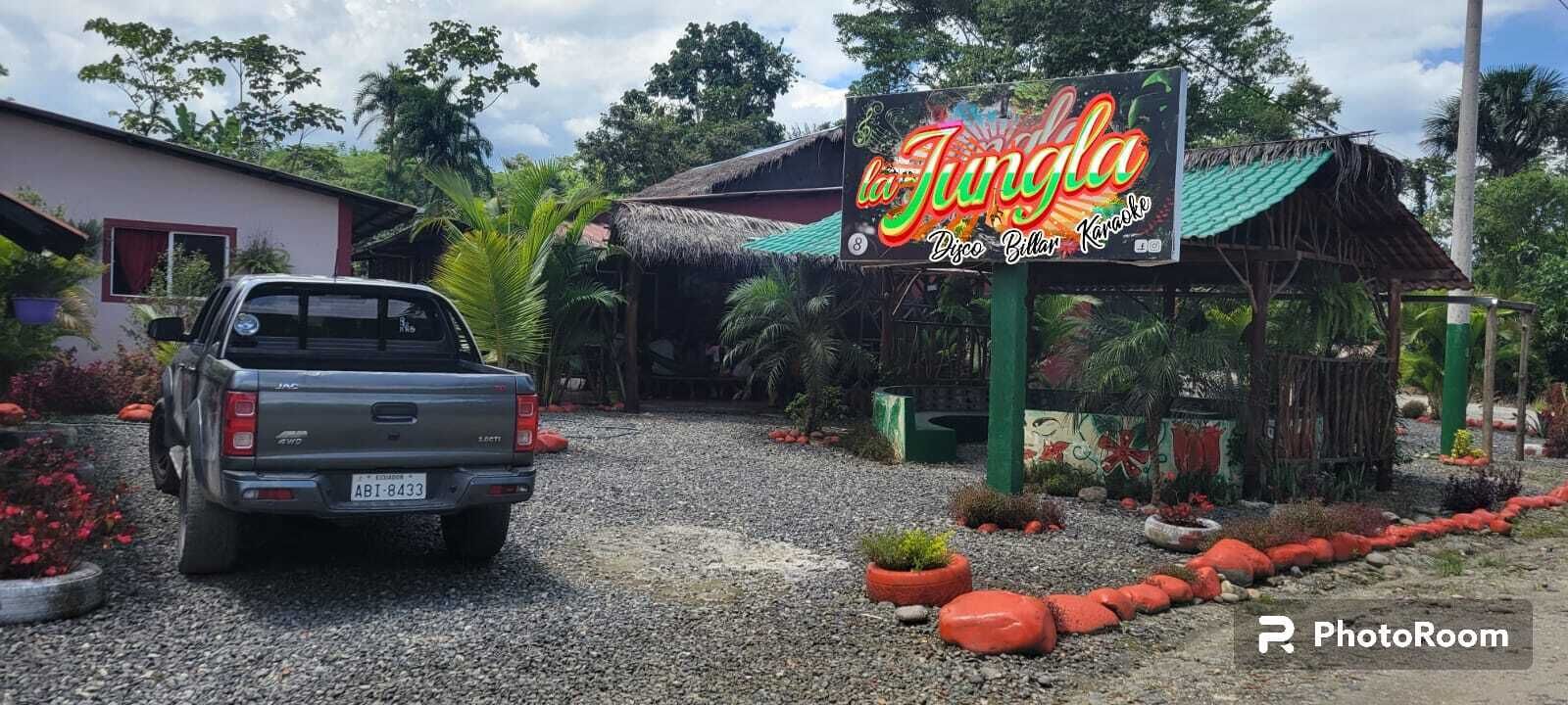 Een grindpad dat leidt naar een gebouw met een bord waarop staat: La Jungle Disco Bilar Karaoke.