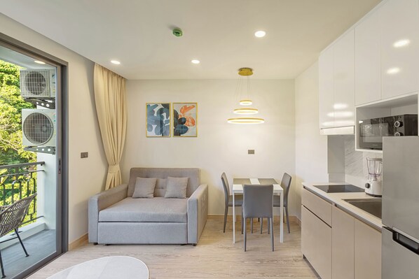 Un apartamento moderno con kitchenette, comedor y sofá.