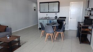 Une cuisine moderne avec un coin repas, un canapé et une table basse.