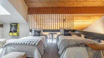 Quarto com duas camas, uma mesinha e vista para o exterior.