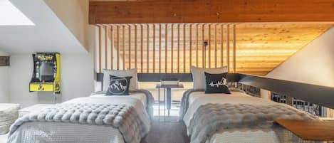 Un dormitorio con dos camas, una mesita y vistas al exterior.