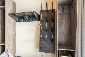 A wall-mounted storage unit with multiple hooks and a shelf.