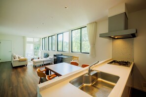 A modern kitchen with a large window, a dining area, and a living room with a sofa and chairs. - Petfriendly Villa Zao with hot spring and open / Katta-gun Miyagi (Katta-gun)