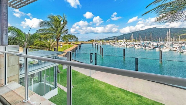 A marina with boats, a clear sky, and a view of the surrounding landscape.