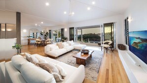 Un salón amplio con un sofá modular grande, una mesa de centro y un ventanal con vistas al exterior.