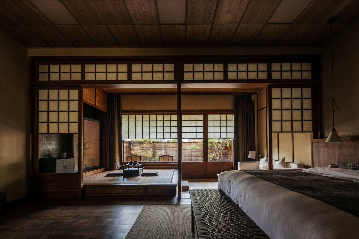 A traditional Japanese-style room with tatami flooring, a low platform, and sliding doors.