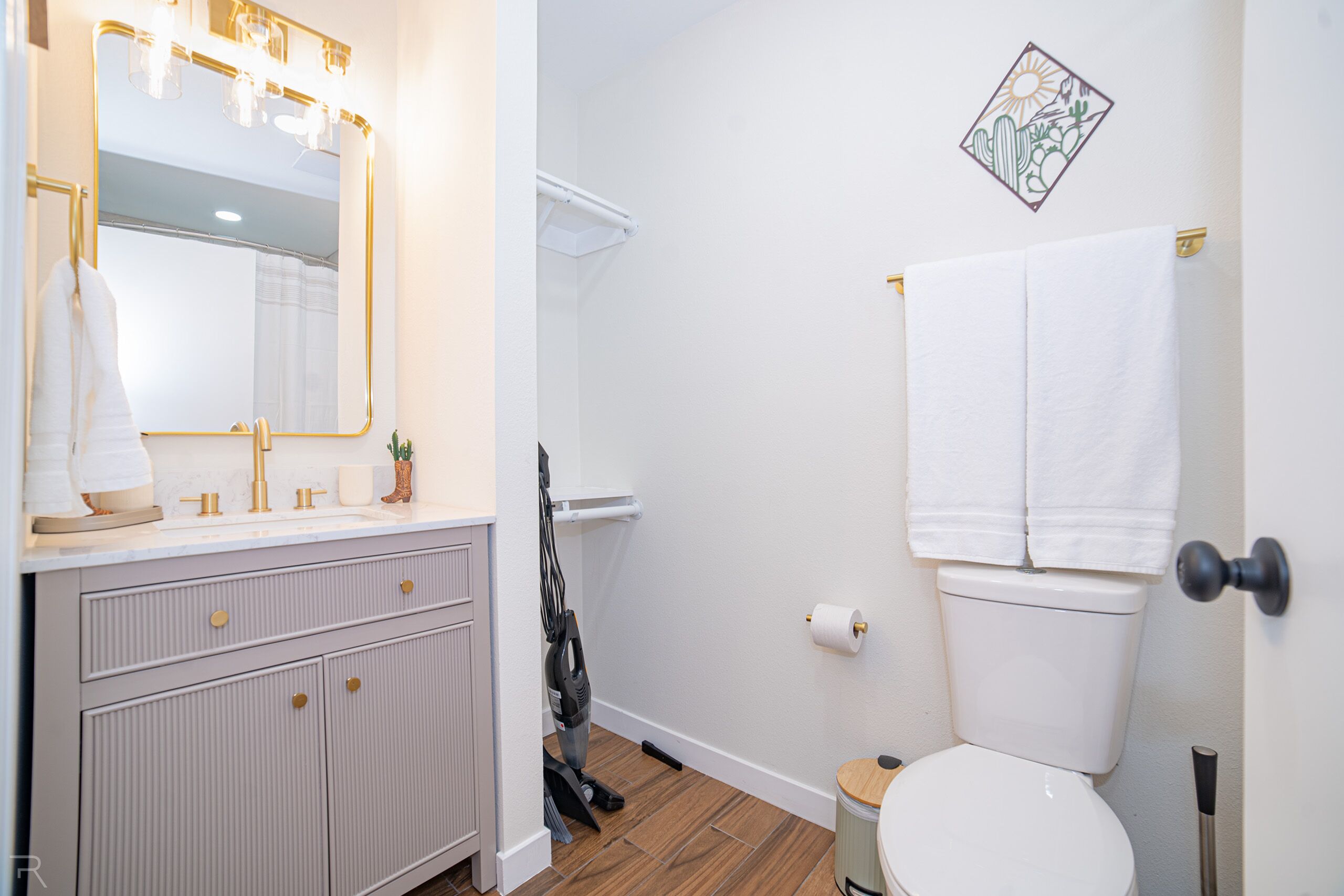 Une salle de bain avec un meuble-lavabo, des toilettes et une douche.