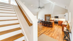 Una cocina moderna con suelo de madera, una isla central y un comedor.