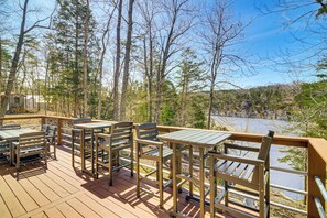 A deck with outdoor seating and a view of a river and forest. - Cumberland Lake Retreat: Furnished Deck & Grill! (Burnside)
