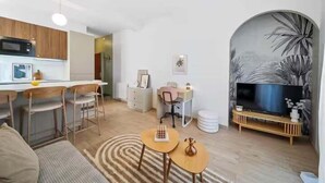 A modern living room with a kitchen area, a dining table, a sofa, and a TV. - Mabulle Originality & Comfort in the Dijon's Heart (Dijon)