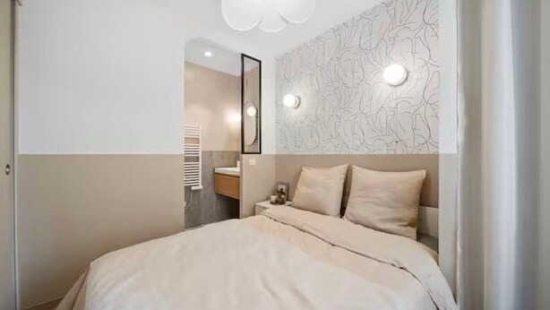A modern bedroom with a large bed, a bedside table, a mirror, and a wall with a floral pattern. - Mabulle Originality & Comfort in the Dijon's Heart (Dijon)