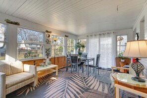 Una habitación acogedora con sofá, mesa de comedor, sillas y alfombra estampada.