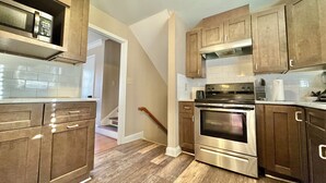 A kitchen with wooden cabinets, a stainless steel oven, and a microwave. - 4BR Home BoA, Discovery, Raptor, USNWC & Uptown (Charlotte)