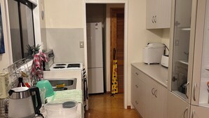 Et lille køkken med et køleskab, komfur og en kaffemaskine på bordet.