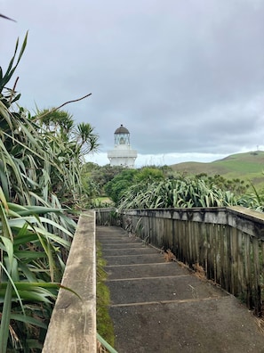 A pathway leading to a lighthouse with a wooden fence on one side and vegetation on the other. - Peaceful & restorative Awhitu Peninsula retreat-80 minutes from Auckland CBD (Awhitu)
