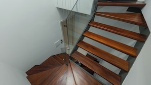 A spiral staircase with wooden steps and glass railings. - Thao Nguyen Homestay Ha Noi (Hanoi)