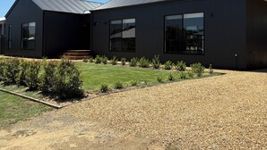 A modern building with a dark exterior, large windows, and a gravel driveway. - Goolwa Beach Pavilion (Goolwa Beach)