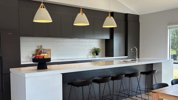 A modern kitchen with a central island, bar stools, and pendant lighting. - Goolwa Beach Pavilion (Goolwa Beach)