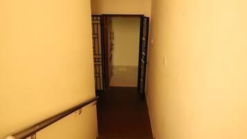 A narrow stairway with a handrail, leading to a door at the top.