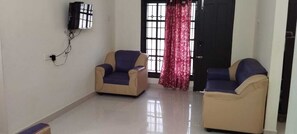 Habitación individual Deluxe, varias camas, balcón | Zona de estar | Televisión LED de 32 pulgadas con canales digitales