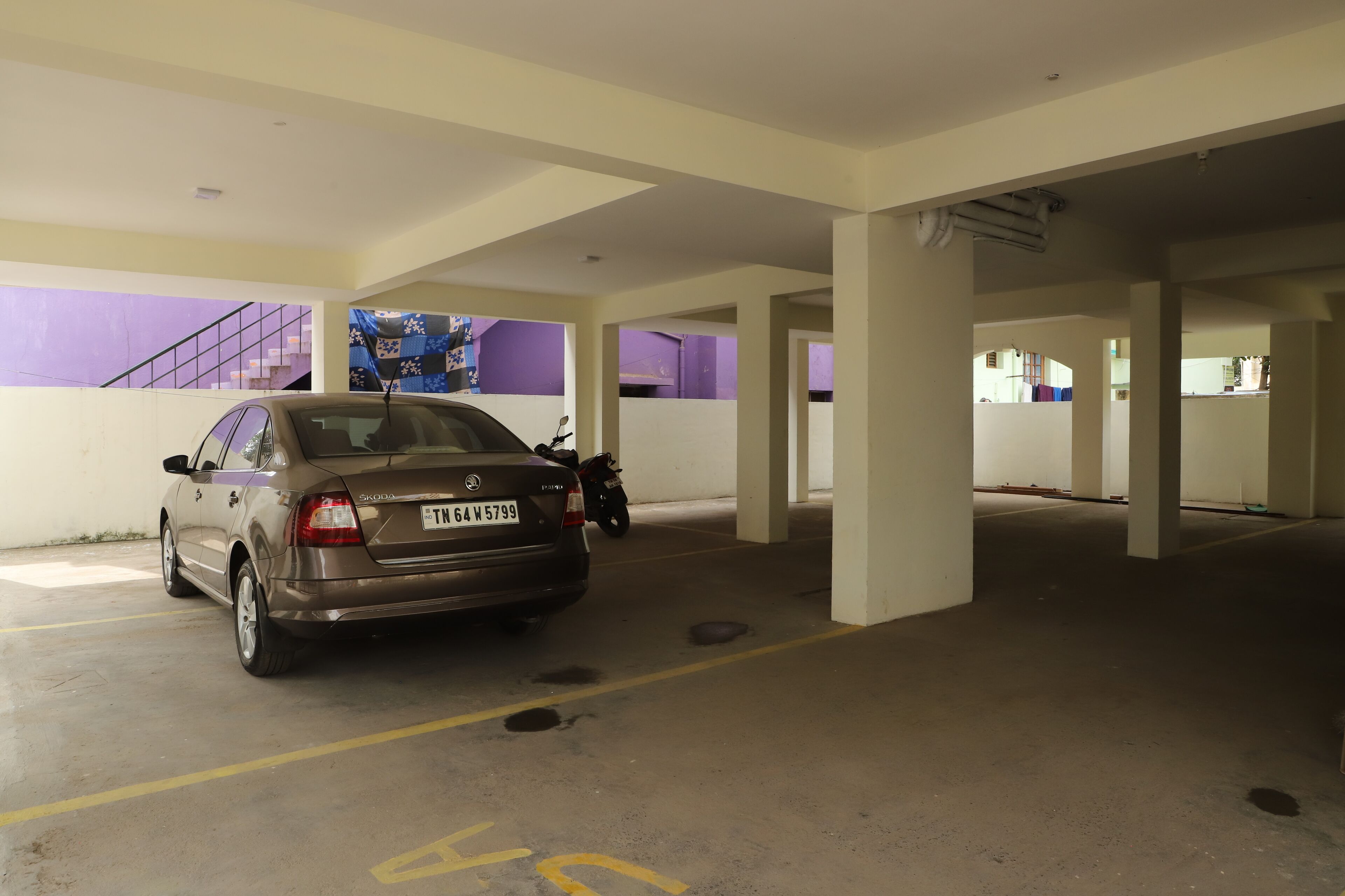 A parking garage with a car parked in a designated space.