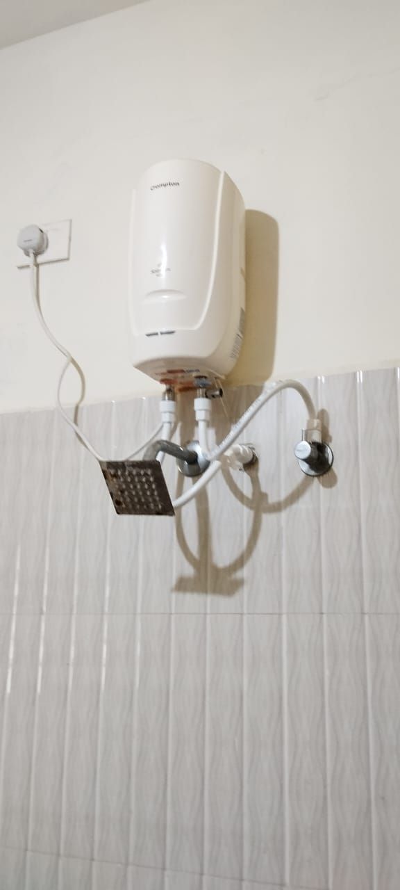 Un baño con ducha empotrada, cabezal de ducha de mano y panel de control.