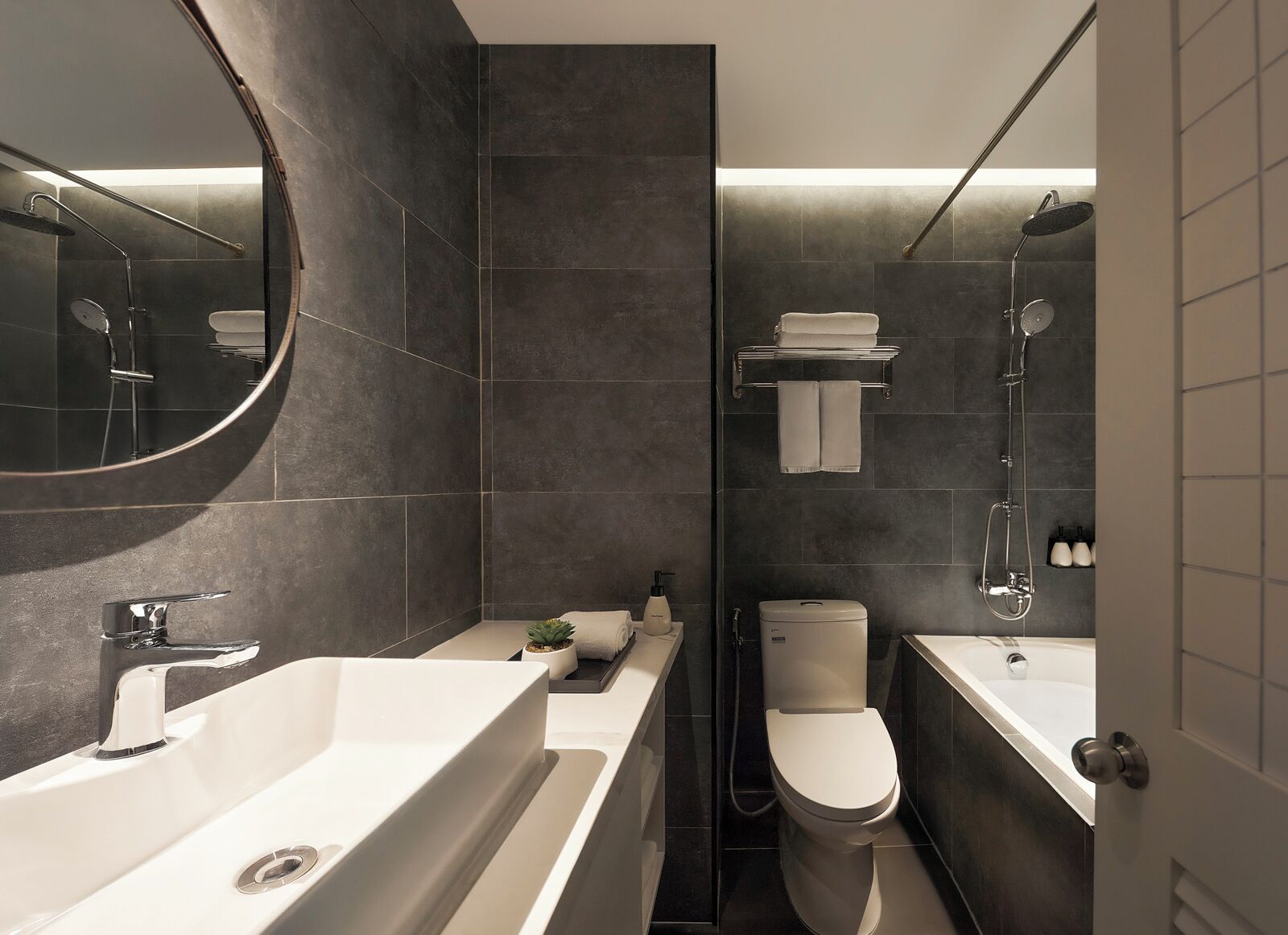 A modern bathroom with a bathtub, a toilet, and a shower area.