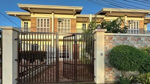 Un área residencial cerrada con muro de piedra y portón metálico.