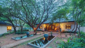 A traditional house with a garden, including a pond and seating area. - Kassapa Lion Rock  (Sigiriya)
