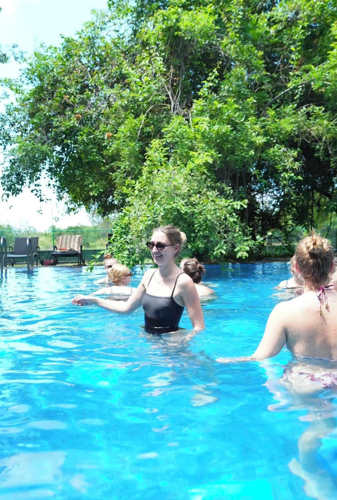 A swimming pool with clear blue water surrounded by lush greenery.