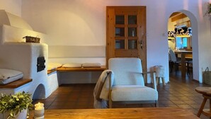 A cozy living room with a wooden ceiling, a bench, a chair, a wooden table, and a door leading to another room. - Country House Goldegg near Ski Slopes (Goldegg - Weng)