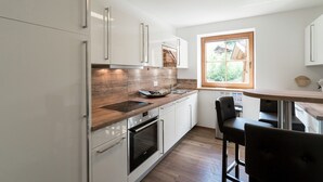 Uma cozinha moderna com eletrodomésticos de aço inoxidável, bancadas de madeira e uma janela que oferece luz natural.