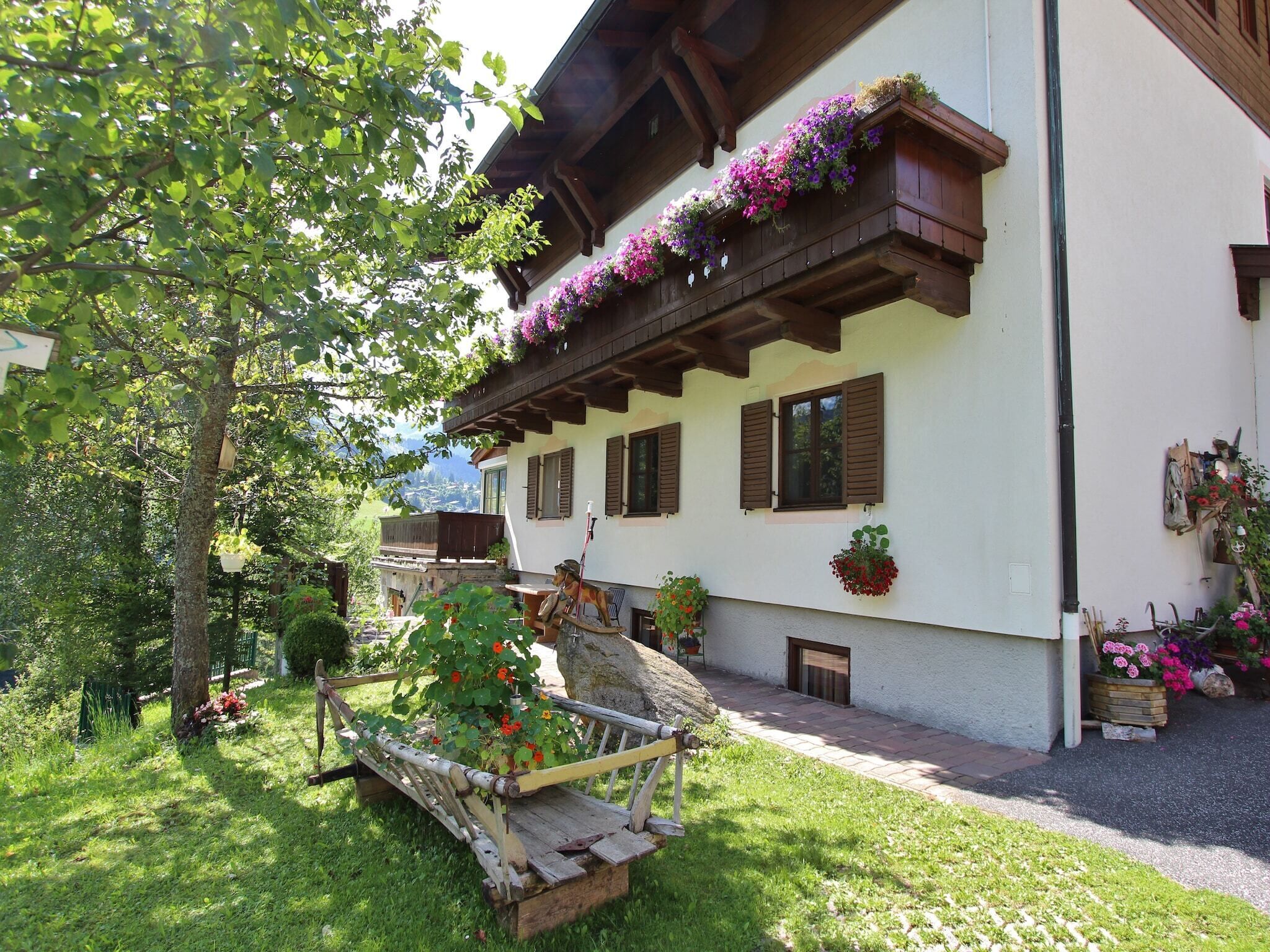 Ein traditionelles Chalet mit Holzbalkonen, einer Steinsitzbank und Blumenkästen.