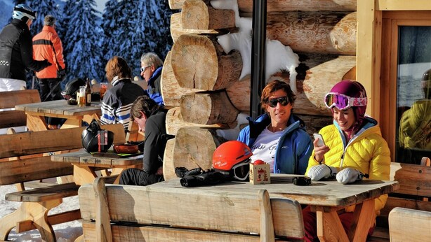 A wooden cabin with a log wall, outdoor seating, and a snowy mountain backdrop. - Chalet in Maria Alm near Hochkönig Ski Lift (Maria Alm)