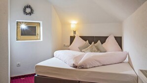 A neatly made bed with a headboard, a wall-mounted light, and a framed picture above it. - Apartment in Kaltenbach near Ski Lift (Kaltenbach)
