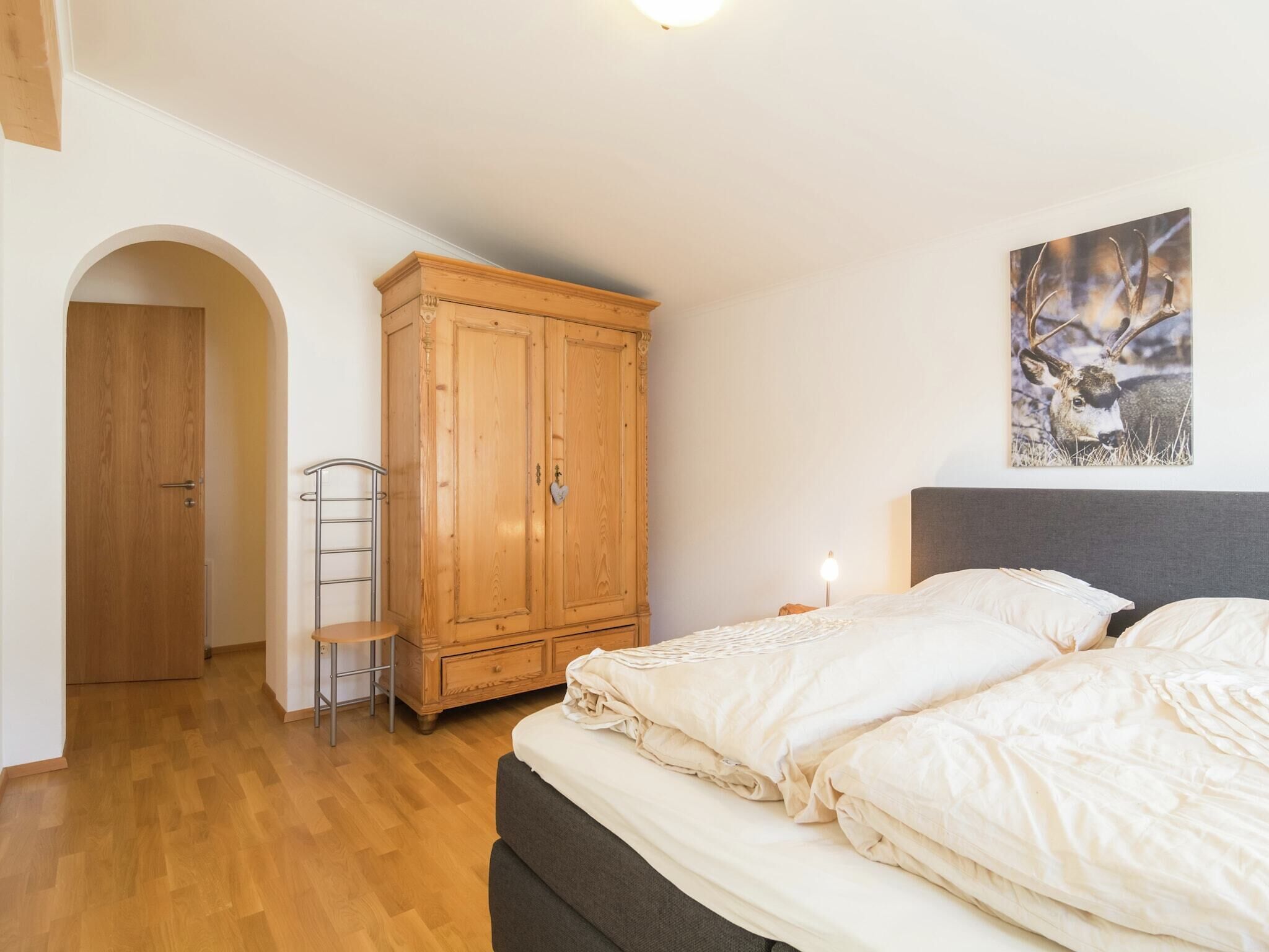 Une chambre à coucher avec un lit, une armoire, une échelle et un tableau accroché au mur.